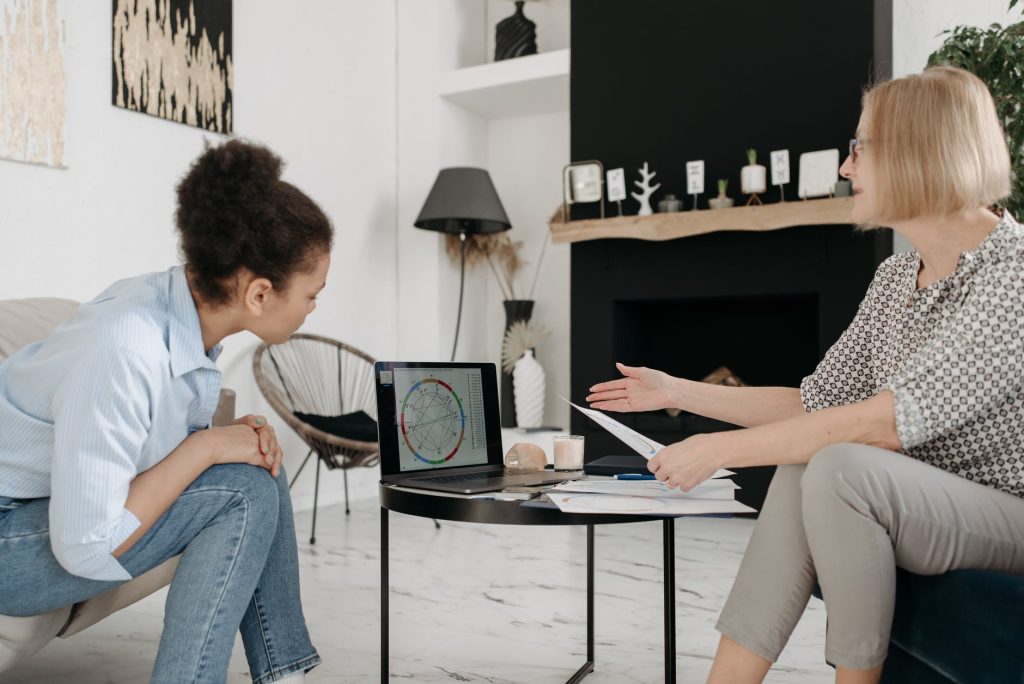 an astrologer explaining a natal chart to a younger woman